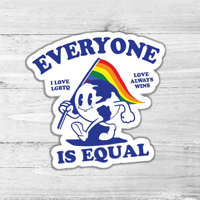 Everyone Is Equal Die Cut Sticker, featuring a cartoon Earth holding a rainbow pride flag with the slogan 'Everyone Is Equal' and additional messages 'I Love LGBTQ' and 'Love Always Wins' on a light wood background.
