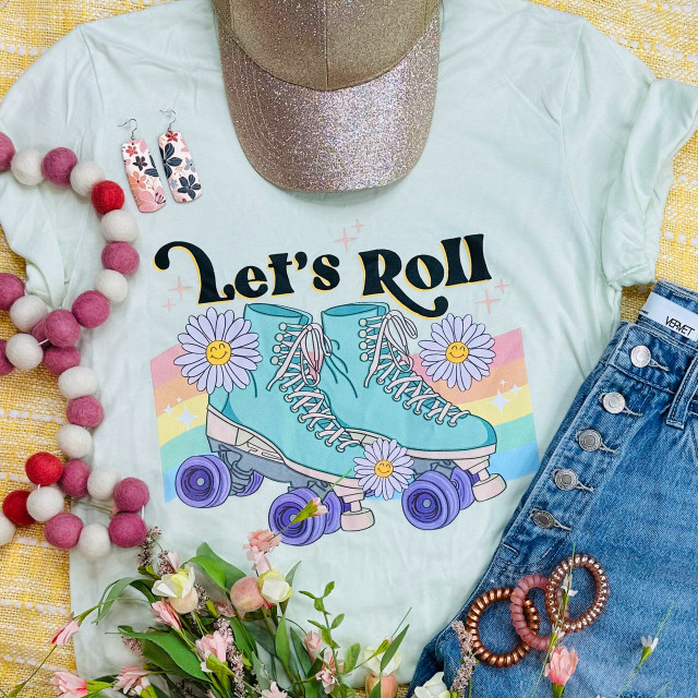 Let's Roll Screen Print Heat Transfer, vibrant graphic print of roller skates on a T-shirt with floral and rainbow design, surrounded by accessories.