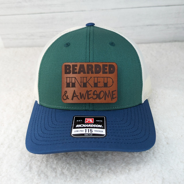 Bearded, Inked & Awesome Leather Hat Patch, colorful trucker cap with green, white, and blue sections and leather patch with text.
