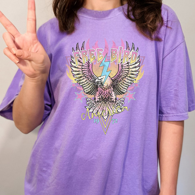 FB Eagle DTF Heat Transfer, graphic design of a colorful eagle with wings spread, lightning bolt, stars, and text on a purple T-shirt.