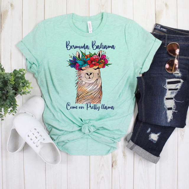 Bermuda Bahama Come On Pretty Llama FINAL STOCK Screen Print Heat Transfer, colorful llama graphic on a mint green T-shirt with text, casual fashion items with ripped jeans, sunglasses, white sneakers, and greenery on a wooden background.