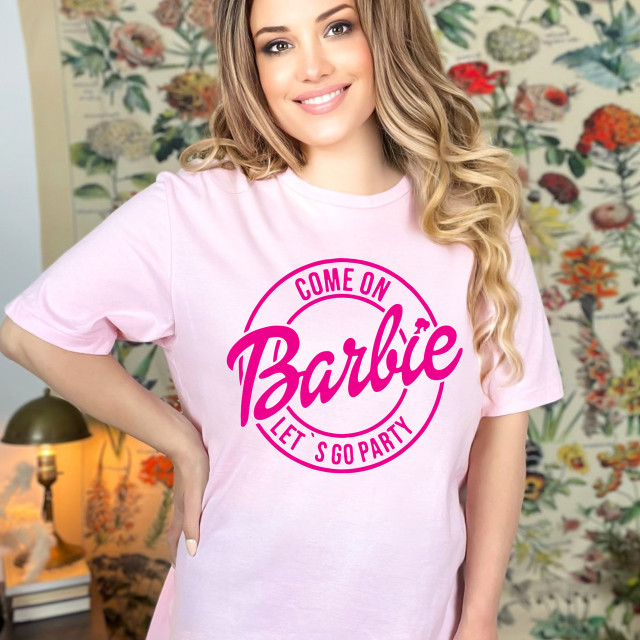 Come On Let's Go Party DTF Heat Transfer, pink graphic design T-shirt with 'Come On Barbie Let’s Go Party' phrase worn by smiling woman.
