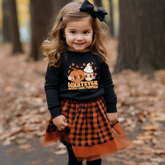 Whatever Spices Your Pumpkin DTF Heat Transfer, cute girl wearing a black shirt with pumpkin and whipped cream design and autumn leaves background