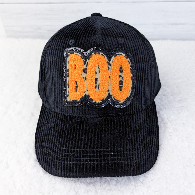 Leopard Boo Hat/Pocket Chenille Patch With Black Glitter, black corduroy baseball cap featuring an orange 'BOO' patch with glitter accents.