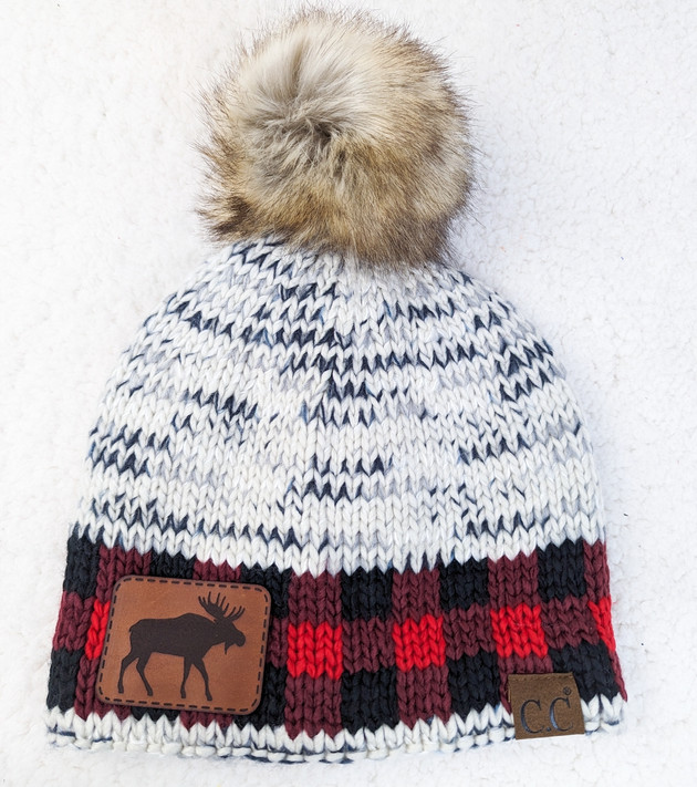 Moose Leather Hat Patch, knitted hat with faux fur pom-pom, detailed moose leather patch and plaid pattern in red, black, and white.