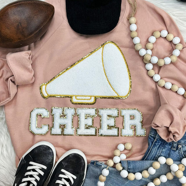 Megaphone & CHEER Chenille Patch Bundle, pink sweatshirt with cheer decal, wooden bead necklaces, black sneakers with white laces, and denim jeans.