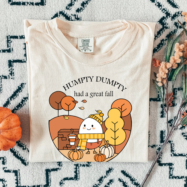 Humpty Had a Great Fall DTF Heat Transfer, a colorful design featuring a cute pumpkin character wearing a scarf and hat, surrounded by autumn trees and pumpkins.