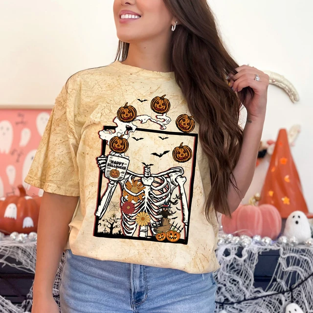 Pumpkin Skeleton DTF Heat Transfer, Halloween themed jump scare skeleton with pumpkin head graphic on a woman's t-shirt.