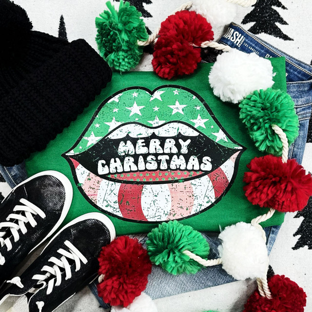 Merry Christmas Lips Screen Print Heat Transfer, festive Christmas-themed lips design with playful colors and distressed style on a green fabric background.