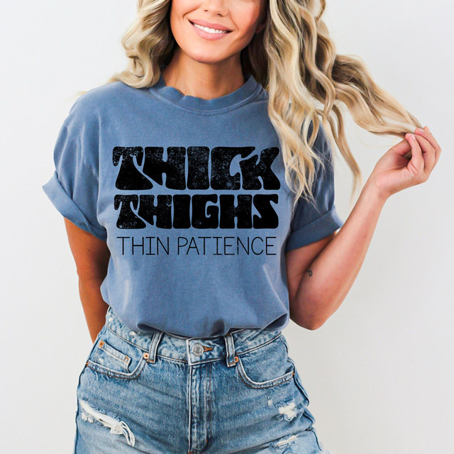 Thick Thighs Thin Patience DTF Heat Transfer, a woman wearing a blue t-shirt with the bold text advertisement, ideal for custom clothing designs.