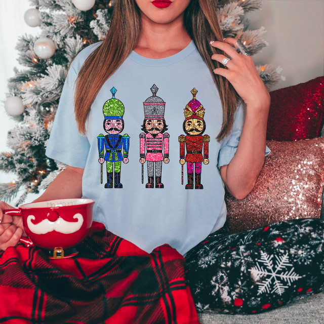 Nutcrackers Faux Sequins DTF Heat Transfer, colorful sequined nutcracker design on a light blue T-shirt, perfect for holiday festive wear.