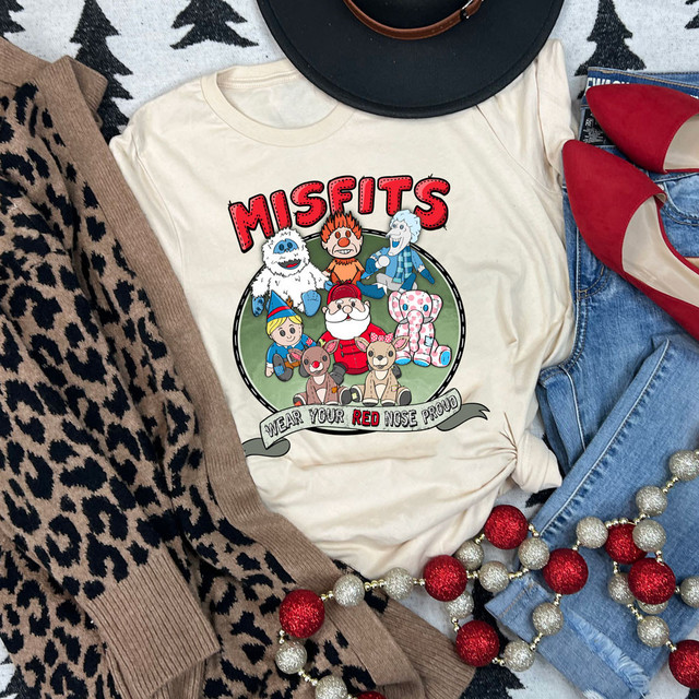Misfits DTF Heat Transfer, colorful cartoon characters from the Misfits series printed on a white t-shirt surrounded by holiday decorations.