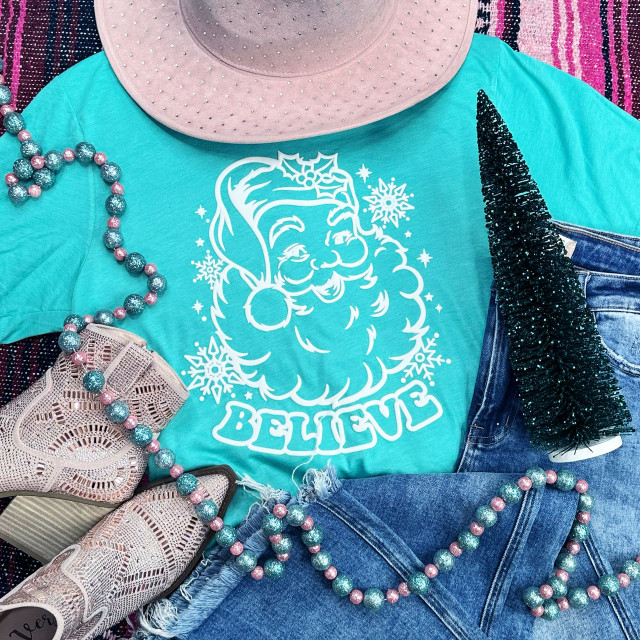 Believe WHITE PUFF Screen Print Heat Transfer, on a teal t-shirt with Santa Claus and the word BELIEVE surrounded by Christmas decorations.