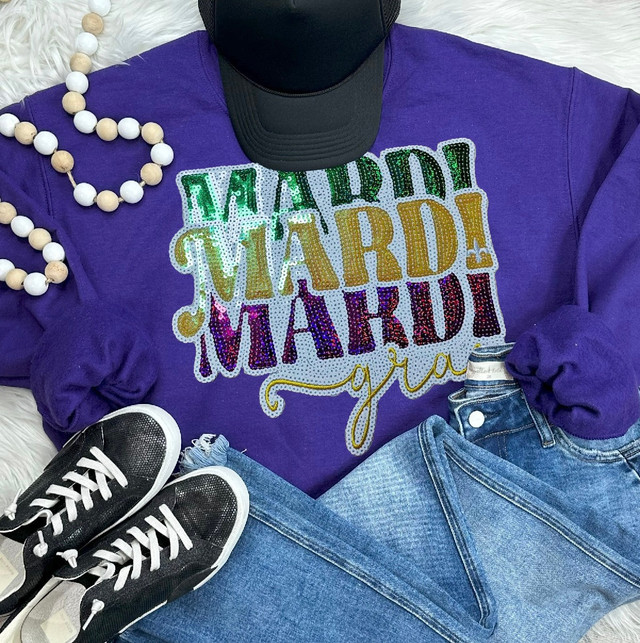 Mardi Gras Sequin Patch, colorful and sparkly sequin patch with the words 'Mardi Gras' in multicolored letters on a purple sweatshirt.