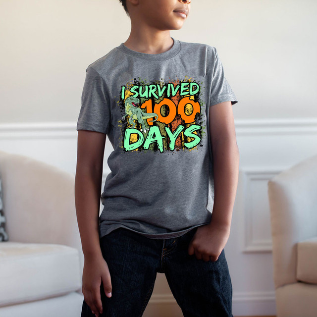 I Survived 100 Days DTF Heat Transfer, a young person wearing a grey T-shirt with colorful graphic design celebrating surviving 100 days.
