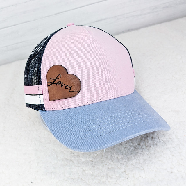Lover Leather Hat Patch, pink and blue trucker hat with a brown leather heart patch embroidered with the word 'Lover'