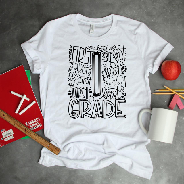 First Grade Typography Word Art Sublimation Transfer, white T-shirt with black handwritten style first grade themed words and illustrations.