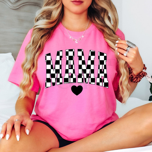 Mama Black/White Checkered DTF Heat Transfer, close-up of a woman wearing a pink t-shirt with a black and white checkered 'MAMA' text and a black heart below, showcasing the product design.