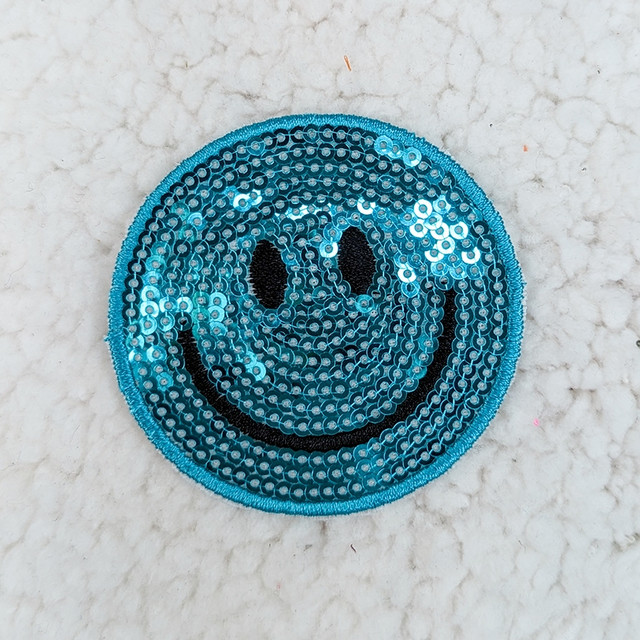 Blue Sequin Happy Face HAT/POCKET Patch, round embroidered patch with a smiling face design made of blue sequins on a white background.