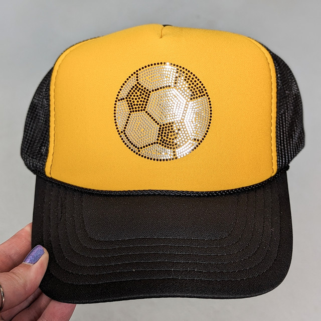 Spangled SOCCER HAT/POCKET Transfer, yellow and black trucker cap with a reflective soccer ball design on the front panel.