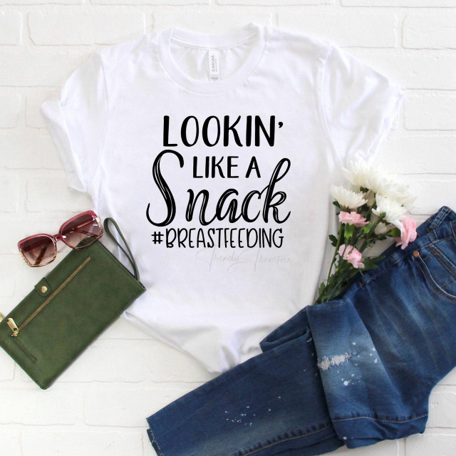 Lookin Like a Snack #Breastfeeding Sublimation Transfer T-shirt with humorous text design, decorated with jeans, pink flowers, sunglasses, and a green wallet.