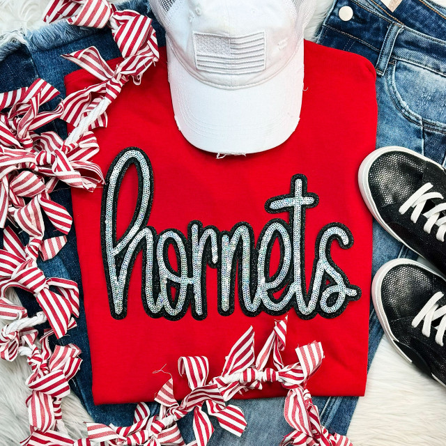 Hornets Sequin Patch, sparkling sequin embroidery patch spelling 'hornets' on red t-shirt surrounded by striped fabric ribbons, denim jeans, white cap, and sneakers.