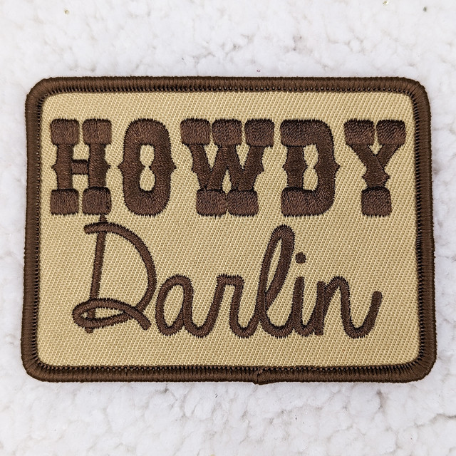 Howdy Darlin Embroidered HAT/POCKET Patch, embroidered patch with the words 'Howdy Darlin' in brown thread on a beige fabric background