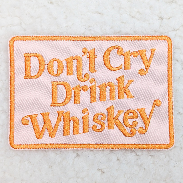 Don't Cry Drink Whiskey Embroidered HAT/POCKET Patch, pink fabric patch with orange embroidered text and border.