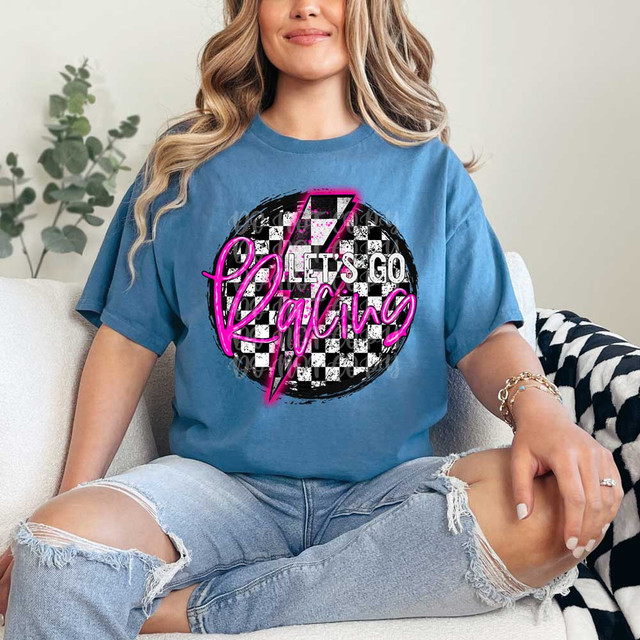 Let's Go Racing DTF Heat Transfer, woman wearing a blue T-shirt with the design featuring a checkered racing circle, pink neon text saying 'Let's Go Racing'.