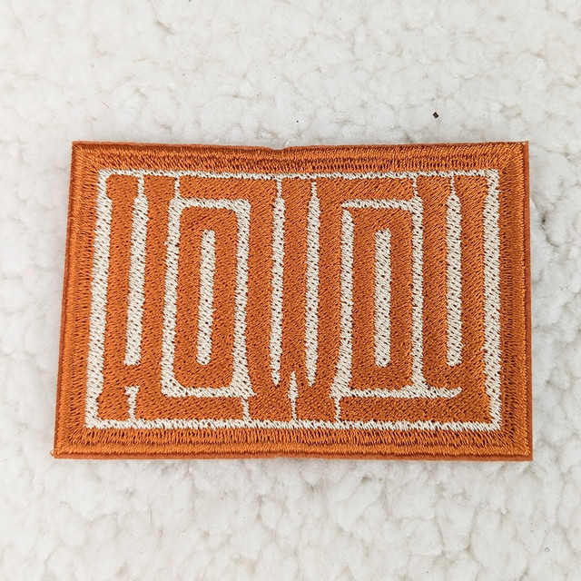 Howdy Embroidered HAT/POCKET Patch, orange fabric patch with white embroidered outline of the word 'Howdy'.