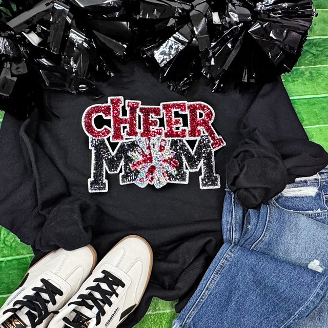 Red Sequin Cheer Mom Patch, sparkling red and white embroidered cheerleading patch with sequins in a floral pattern, on black fabric sweatshirt with cheerleading decorations.