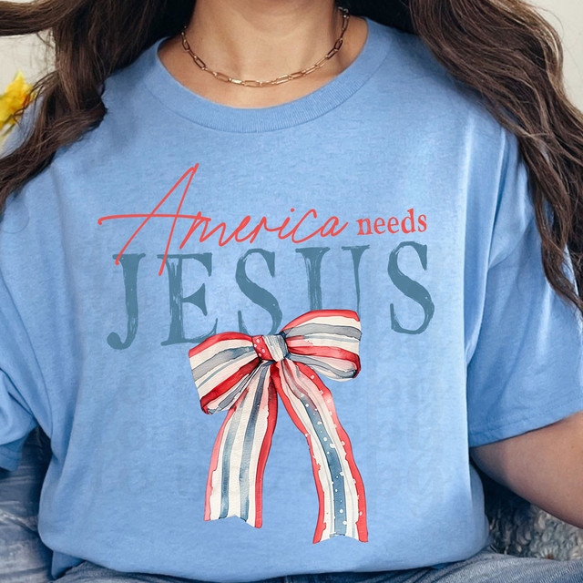 America Needs Jesus DTF Heat Transfer, patriotic-themed T-shirt with a red, white, and blue striped bow design.