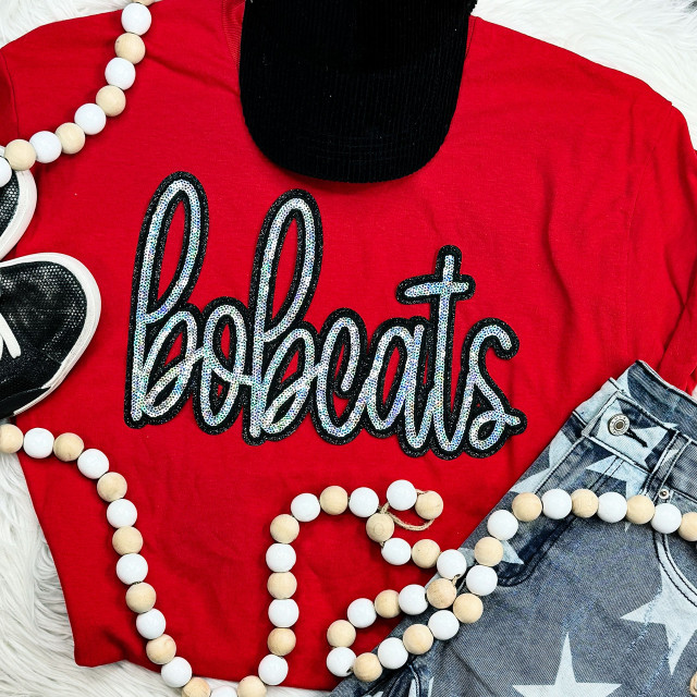 Bobcats Sequin Patch, sparkling decorative patch with the word 'behaviors' on a red shirt, styled with black boots, a beaded necklace, and star-patterned jeans.