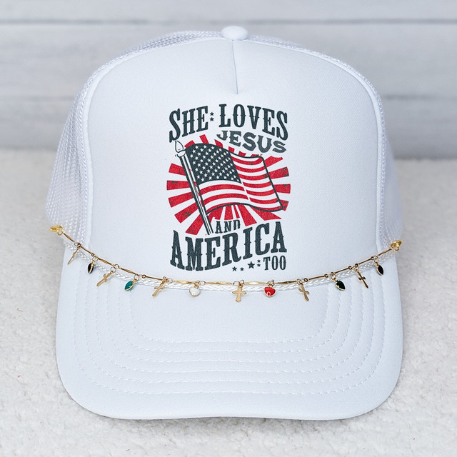 Hearts and Cross Charms Hat Chain, a gold decorative chain with small heart and cross pendants, draped across a white baseball cap with patriotic message and American flag graphic.