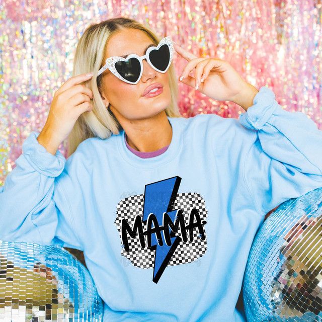 Mama Blue Bolt DTF Heat Transfer, vibrant image showing a woman wearing a light blue sweatshirt and heart-shaped sunglasses, with a Mama-themed graphic design on her shirt, surrounded by shiny disco balls and a colorful metallic background.