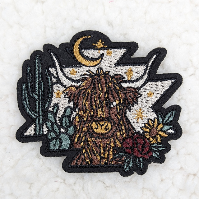 Shaggy Cow Embroidered HAT/POCKET Patch, detailed embroidery of a shaggy cow with celestial elements and desert plants.