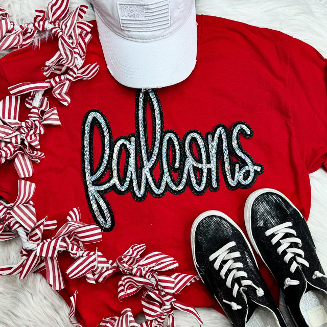 Falcons Sequin Patch, black and white sequin embroidered patch spelling 'falcons' on a red t-shirt surrounded by striped bows, a baseball cap, and black sneakers.