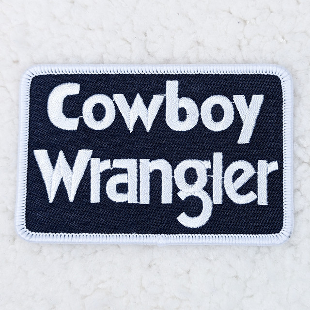 Cowboy Wrangler Embroidered HAT/POCKET Patch, embroidered patch featuring the text 'Cowboy Wrangler' with decorative stitching.
