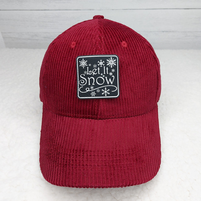 Let It Snow FAUX Leather Patch, red corduroy cap with embroidered patch featuring snowflakes and the text 'Let It Snow'.