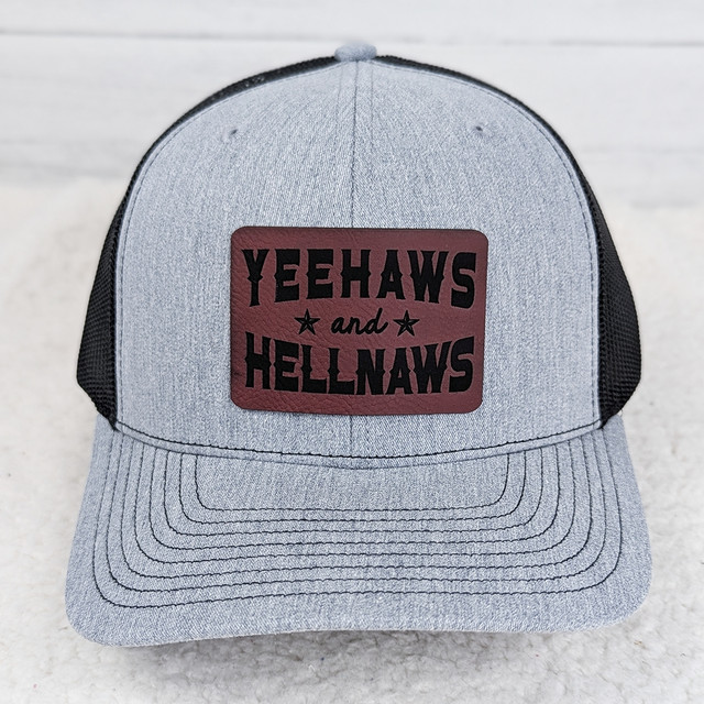 Yeehaws and Hellnaws FAUX Leather Patch - A gray and black trucker cap with a rectangular faux leather patch featuring the brand name and slogan.