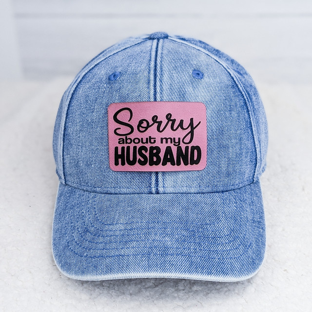 Sorry About My Husband FAUX Leather Patch, light blue denim baseball cap with a pink patch that has black text reading Sorry about my HUSBAND.