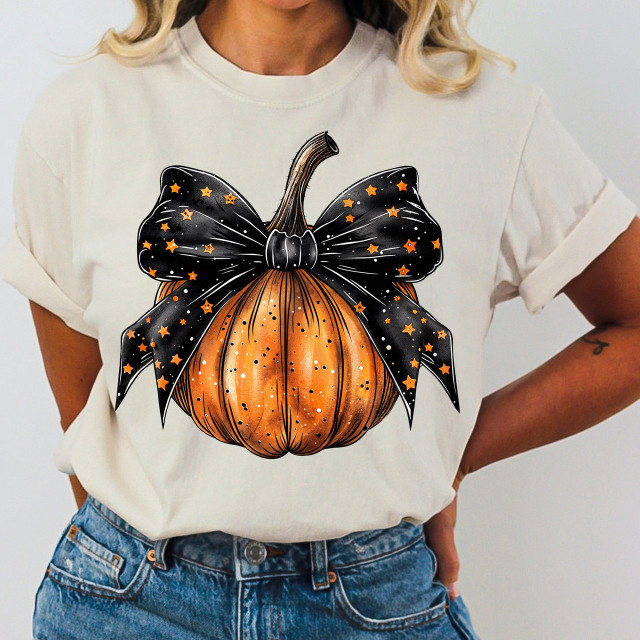 Pumpkin Bow DTF Heat Transfer, image of an orange pumpkin with a black bow featuring star patterns, applied on a white t-shirt.