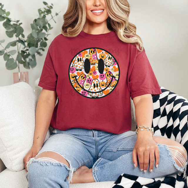 Ghost Happy Face DTF Heat Transfer, a colorful halloween-themed smiling face made of pumpkins, ghosts, and other spooky elements on a dark background.