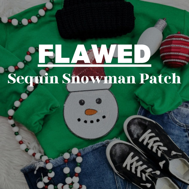 Flawed Sequin Snowman Patch, close-up of a Christmas-themed patch with sequins depicting a snowman's face, on green fabric with holiday decorations and accessories around it.