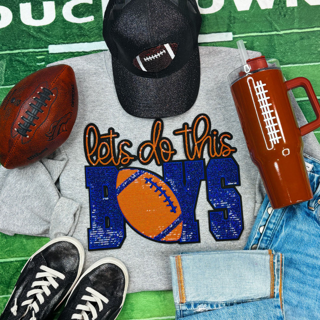 Let's Do This Boys Royal/Orange Sequins Patch, a colorful patch with the words 'Let's Do This' and 'BOYS' featuring a football design in orange and blue, appliqued on a gray sweatshirt.