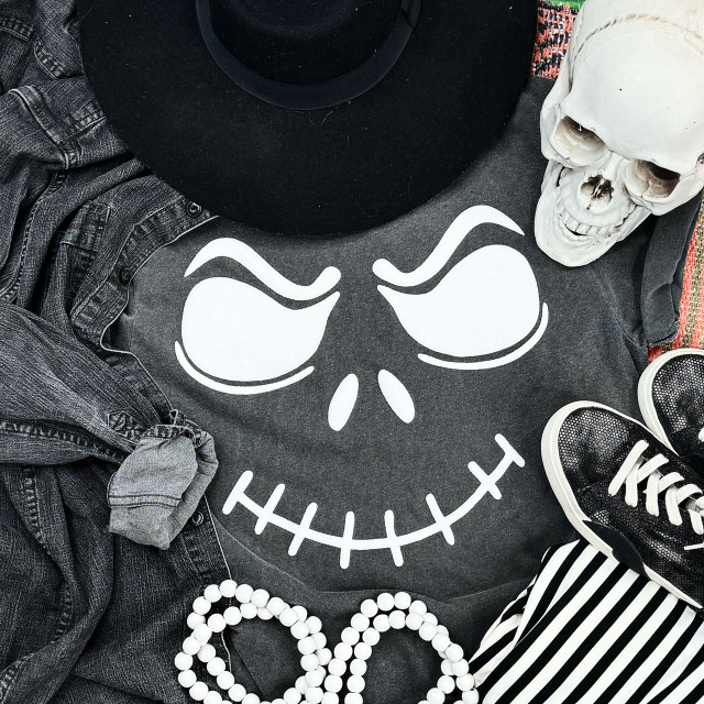 White Glitter Raised Jack Face Transfer, Halloween-themed face graphic with glittery details on dark clothing surrounded by accessories and props.