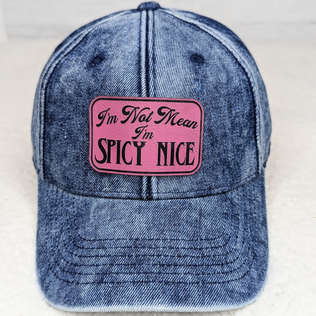 I'm Not Mean I'm Spicy Nice FAUX Leather Patch, denim baseball cap with pink patch featuring playful text.