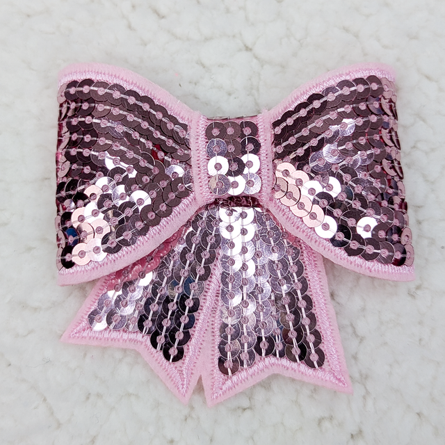 Light Pink Sequin Bow Hat/Pocket Patch, decorative pink fabric bow with shiny pink and purple sequins and embroidery, suitable for clothing or accessories.