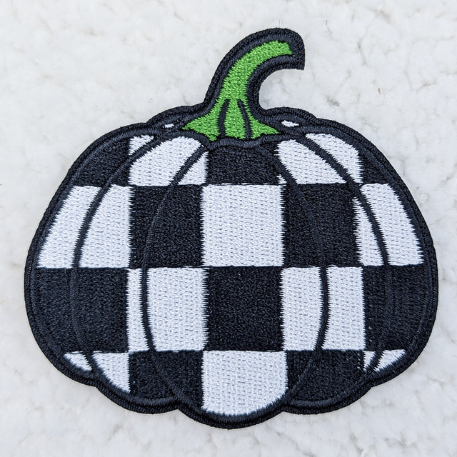 Checkered Pumpkin Embroidered HAT/POCKET Patch, a decorative patch featuring a pumpkin design with a black and white checkered pattern and green stem.