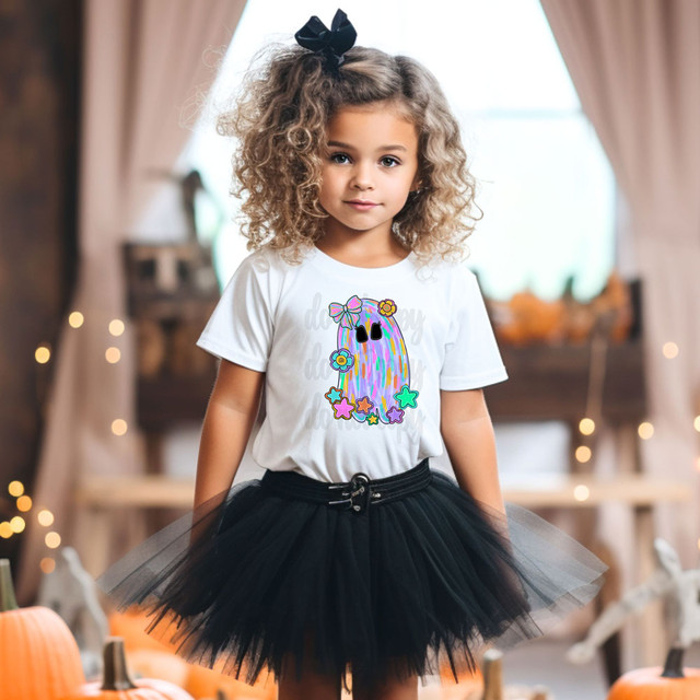 Star Ghost With Bow DTF Heat Transfer, a colorful ghost design with bows and flowers on a white t-shirt worn by a young girl indoors.
